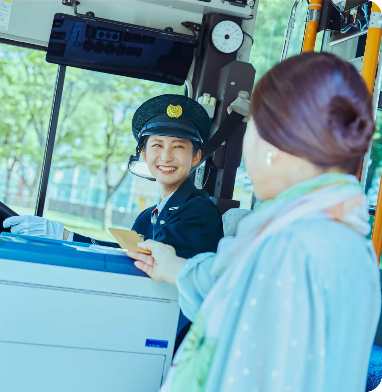 降車中の乗客を笑顔で見送る女性運転士